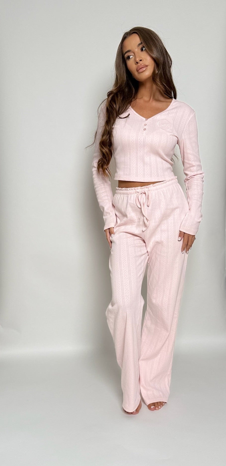 Ensemble de pyjama rose poudré Pointelle Ballet – haut et pantalon en maille pointelle douce, coupe féminine et élégante, fond blanc studio.